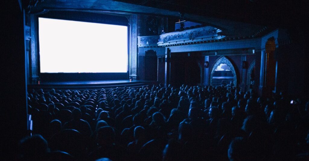 A full cinema theater in Budapest with an audience watching a movie at night.