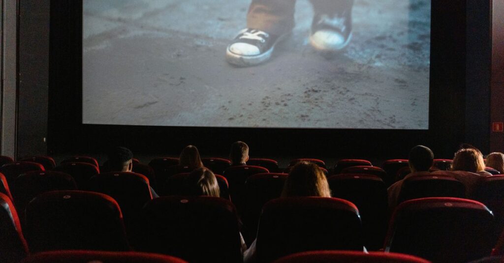 A group of people enjoying a film in a cinema with a large screen.