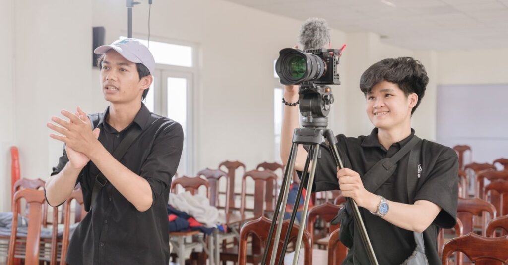 Two young filmmakers working with a camera in a bright studio.
