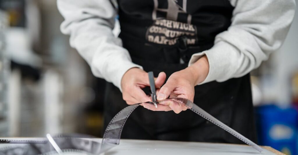 A person skillfully cutting a film strip in a photography studio setting.