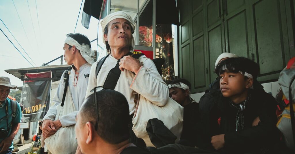 Group of adults and teenagers in traditional attire, engaged in street scene with vibrant atmosphere.