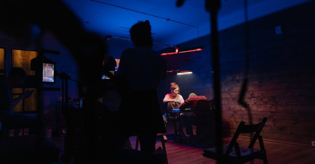 A creative team working in a neon-lit studio with camera equipment and electric lighting.