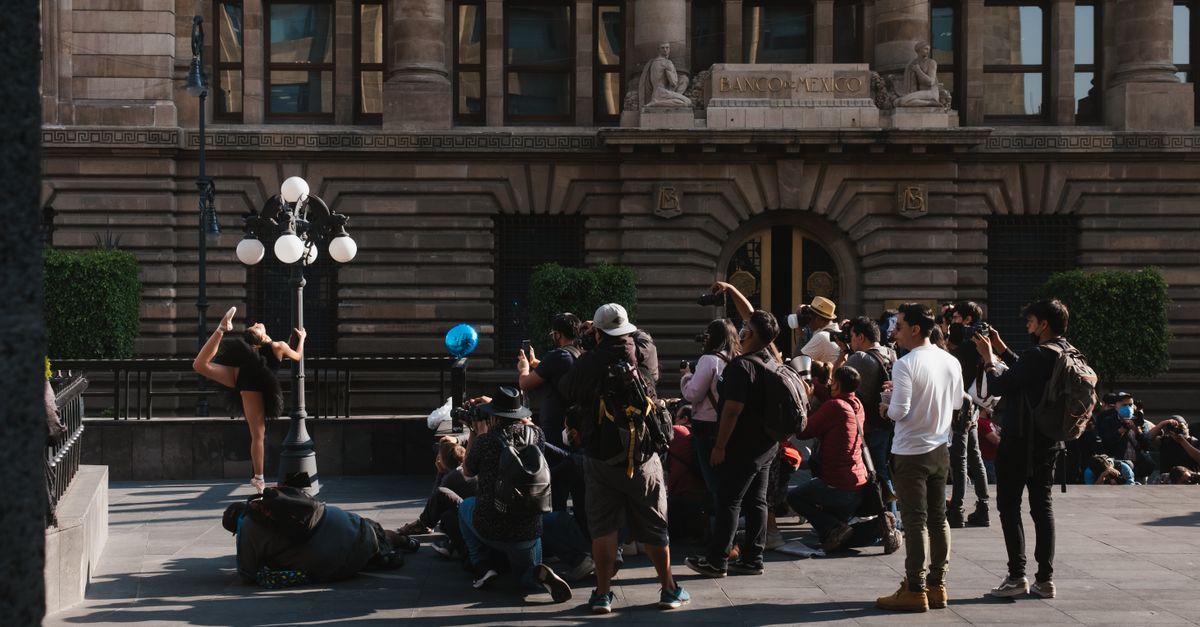 Energetic street performance with photographers capturing the moment outside Banco building.