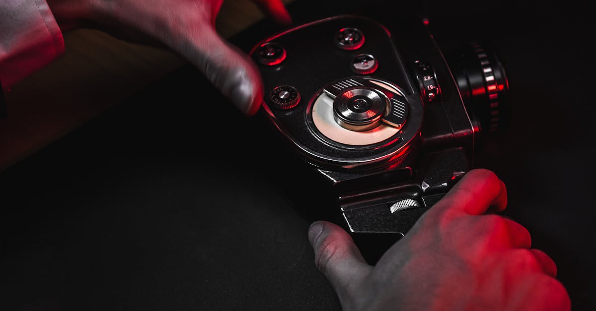 Close-up of hands holding a vintage film camera with dramatic red lighting.