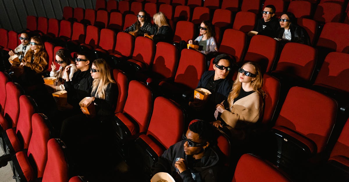 People enjoying a film in a cinema, wearing 3D glasses and eating popcorn.