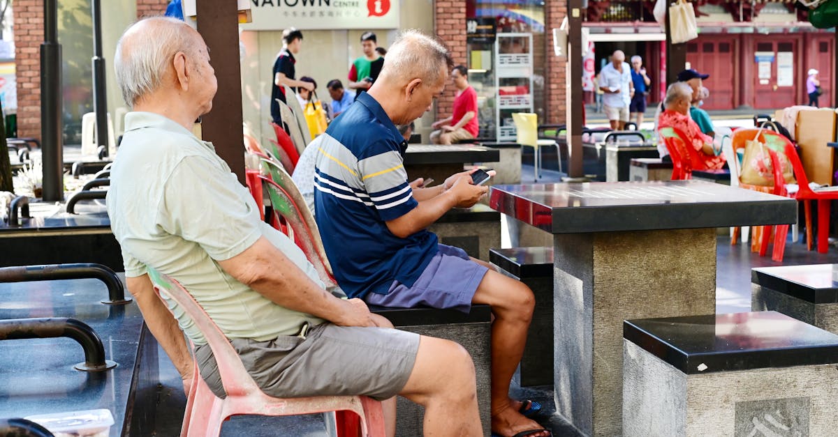 People relaxing in Singapore's Chinatown amidst a bustling street atmosphere.