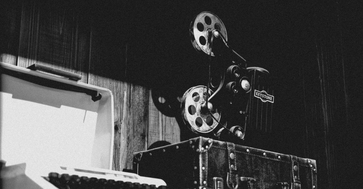 Monochrome image of a vintage typewriter and retro film projector evoking historical nostalgia.