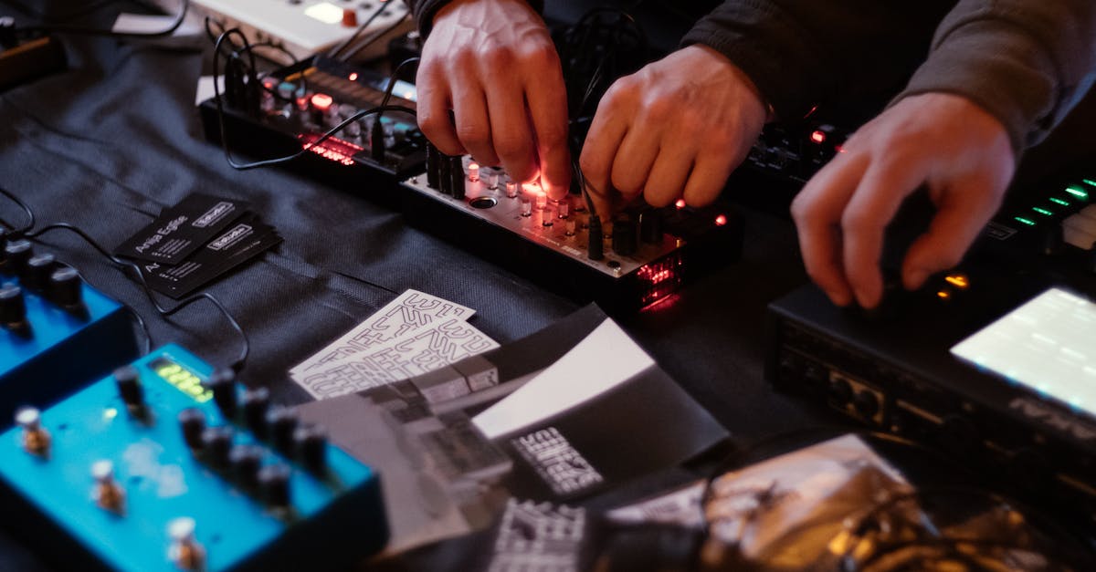Close-up of hands adjusting knobs on audio equipment in a music studio.