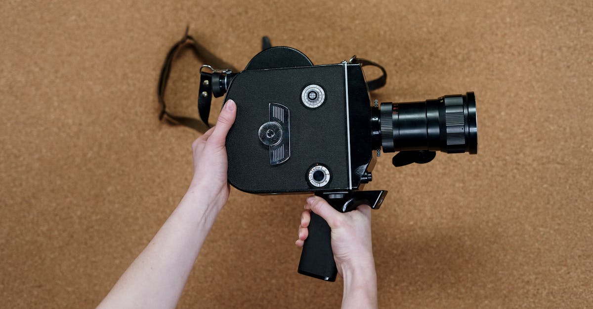 A person holds a vintage cinema camera over a corkboard background, showcasing a retro aesthetic.