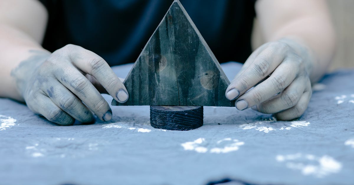 Hands crafting textiles with a wooden stamp, showcasing artistic creativity.