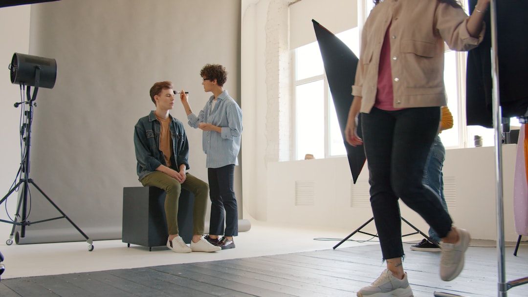 Makeup artist applying makeup to a model in studio.