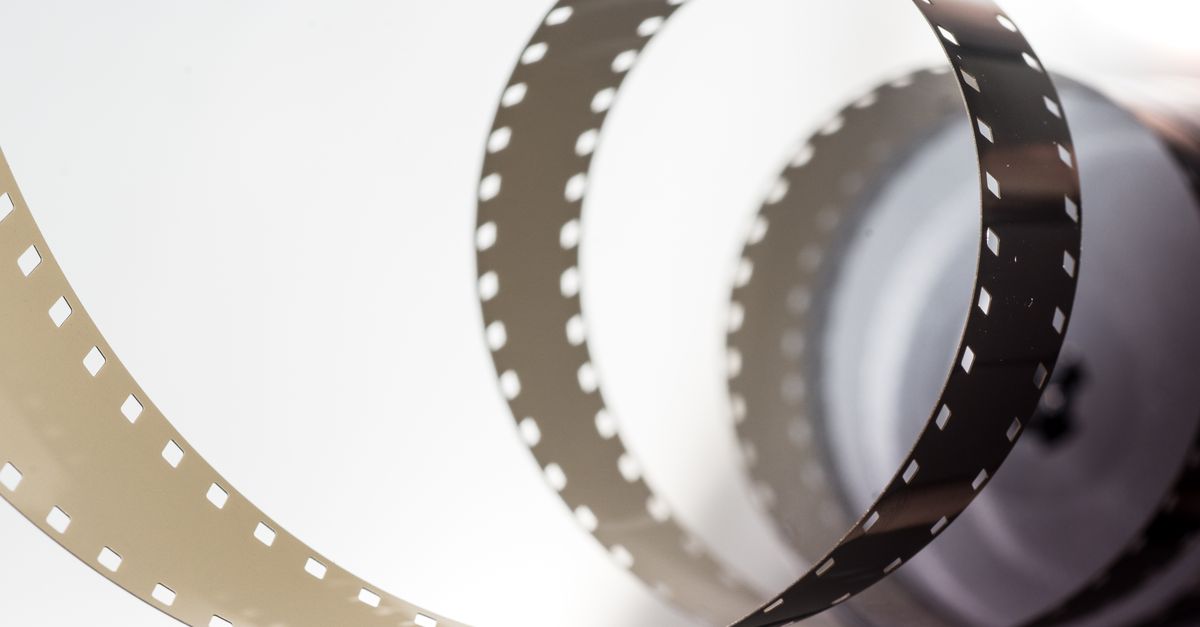 Close-up artistic view of a vintage filmstrip in a spiral design, highlighting its metallic texture.