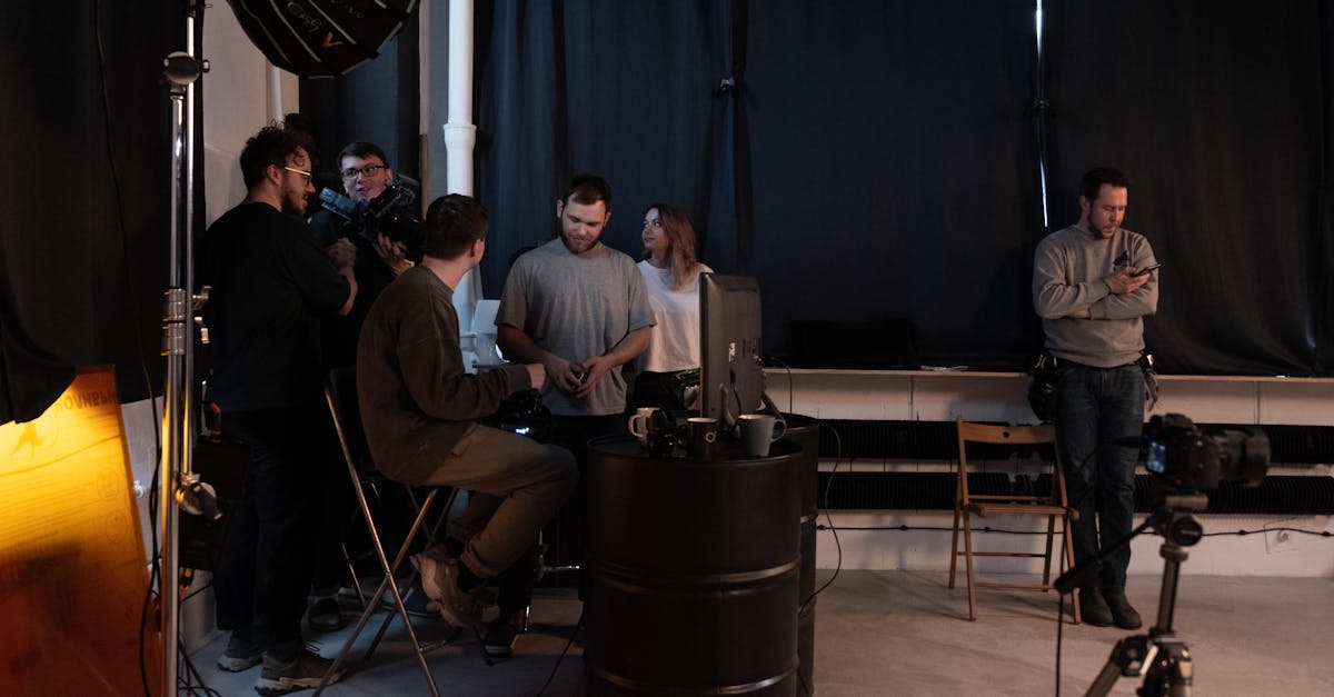 A group of people collaborating in a dimly lit photo studio, setting up for a creative project.