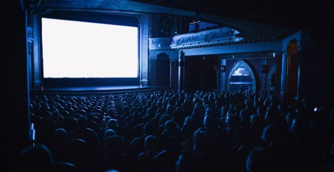A full cinema theater in Budapest with an audience watching a movie at night.