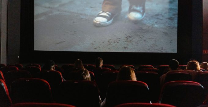 A group of people enjoying a film in a cinema with a large screen.
