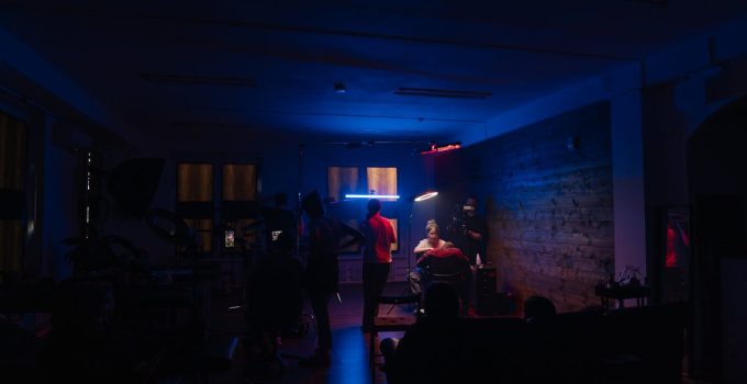 A dimly lit tattoo studio with artists working under neon lights, creating an immersive creative scene.