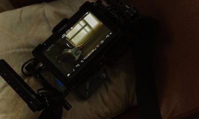 Camera screen displays a woman indoors, showing a cinematic scene.