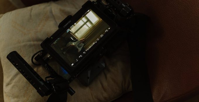 Camera screen displays a woman indoors, showing a cinematic scene.