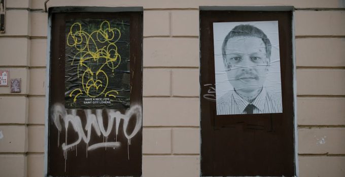 City building facade featuring graffiti and artistic posters for street art culture enthusiasts.