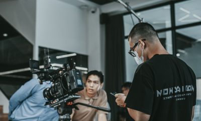Camera crew working on a film set in Vietnam, capturing cinematic scenes indoors.