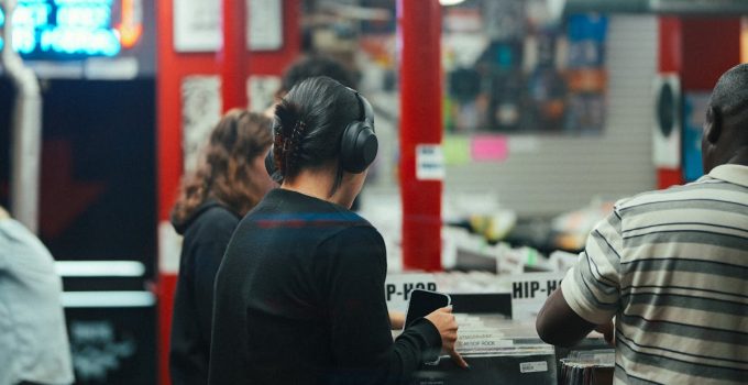 People exploring vinyl records in a bustling music store with vibrant atmosphere.