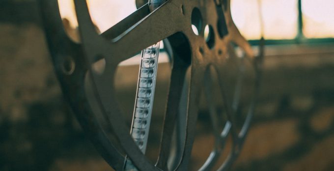 Artistic shot of a vintage film reel with soft light creating a nostalgic atmosphere.
