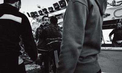 Candid black and white street photo depicting a group of people interacting energetically.
