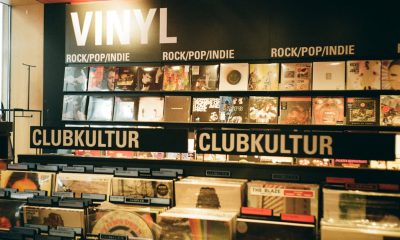 A vibrant indie music store displaying a variety of vinyl records under the categories rock, pop, and club culture.
