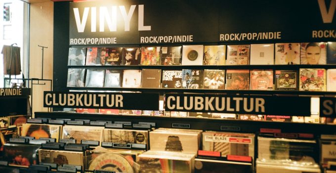 A vibrant indie music store displaying a variety of vinyl records under the categories rock, pop, and club culture.