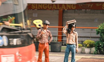 Two stylish street musicians with a guitar and retro outfits in Jakarta, Indonesia