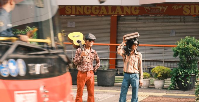 Two stylish street musicians with a guitar and retro outfits in Jakarta, Indonesia