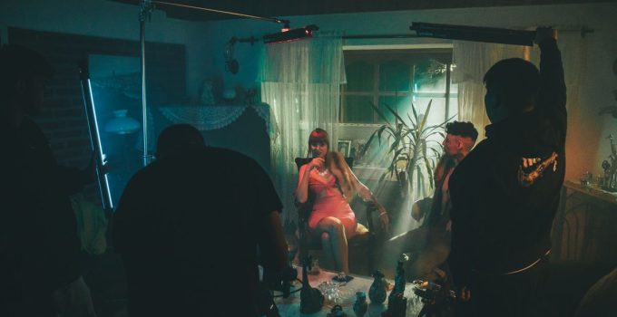A stylized film set scene with people in a dimly lit room, creating a cinematic atmosphere.